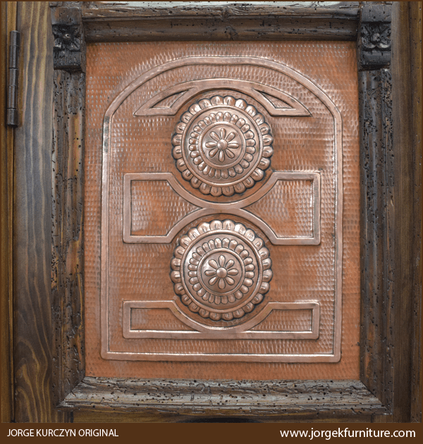 Close-up of Zoila-Elisa II armoire’s copper panel with hand tooled conchos and scroll carvings