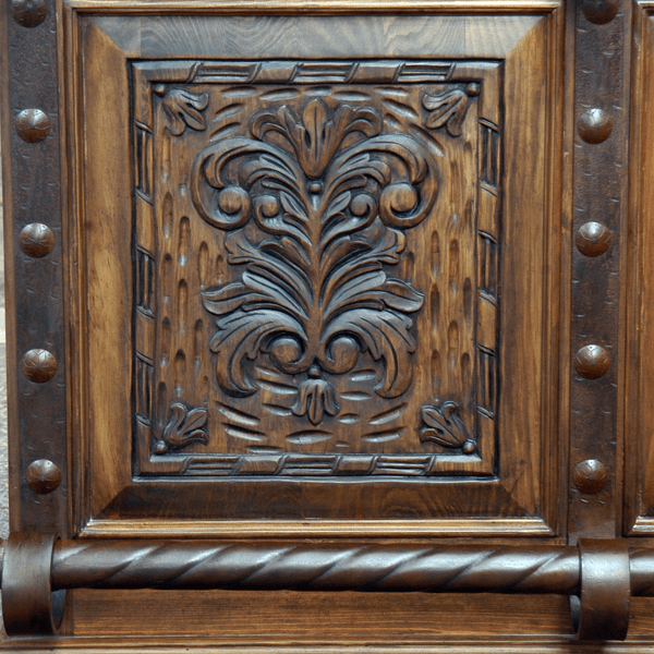 Detail of hand-carved wood scrolls and forged iron nails with spiral rail