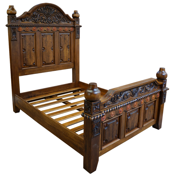 Semi-front view of Spanish colonial bed with hand tooled copper details and carved wood